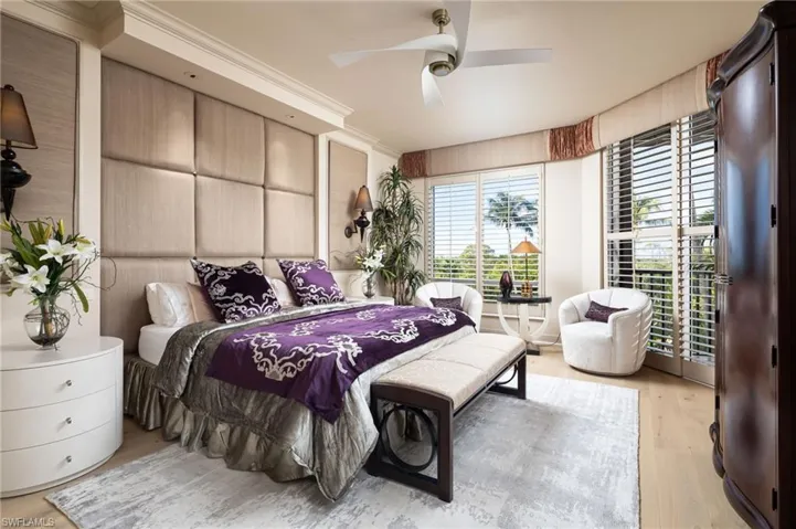 Bedroom with light wood-style flooring, a ceiling fan, and crown molding