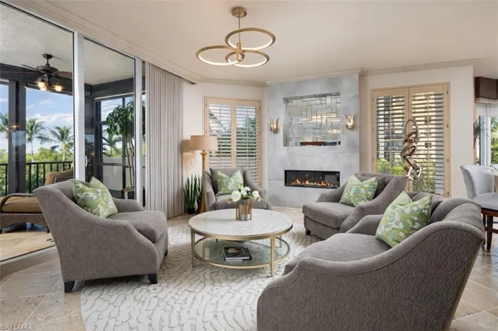 Living room featuring healthy amount of natural light, crown molding, and a tile fireplace