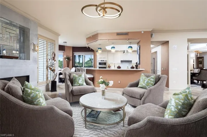 Living room featuring crown molding and a high end fireplace