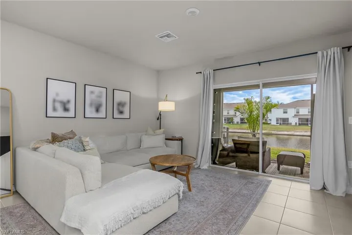 Living room featuring light tile patterned flooring and a water view