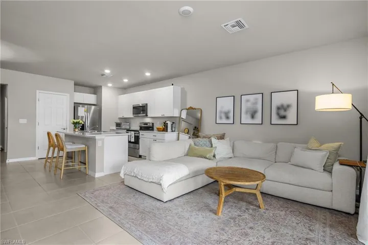 Living room with recessed lighting and light tile patterned flooring