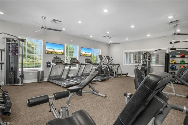 Workout area with a ceiling fan and recessed lighting