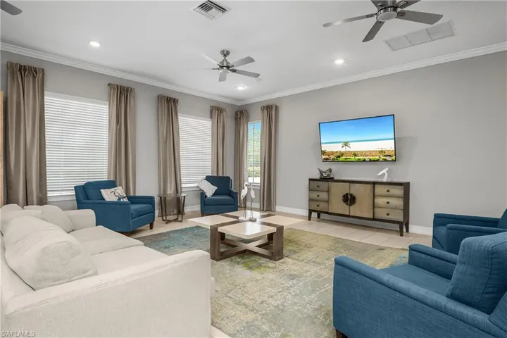 Living room featuring a ceiling fan, ornamental molding, and recessed lighting