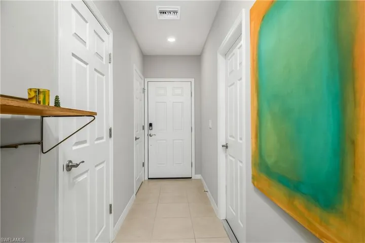 Doorway with tile patterned flooring and recessed lighting