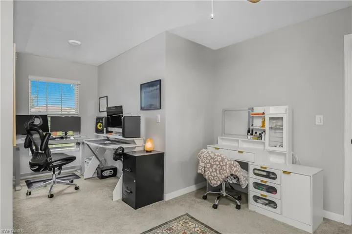 Home office featuring light carpet and a ceiling fan