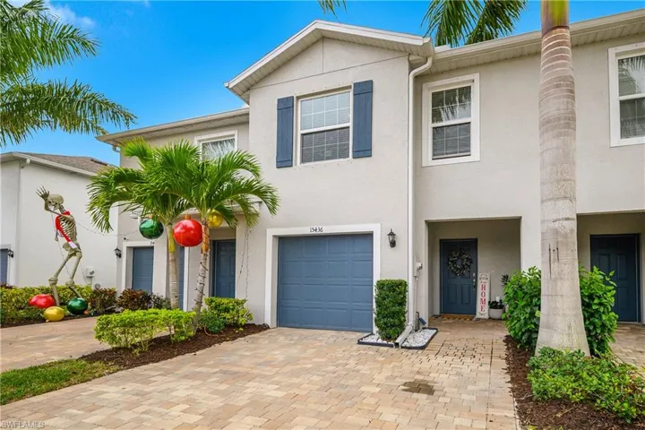 Traditional home featuring stucco siding, a garage, and decorative driveway