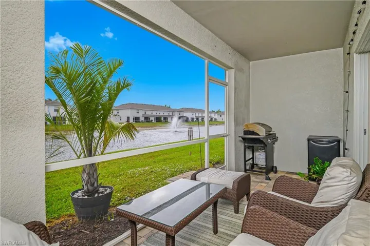 View of patio featuring a water view, area for grilling, and a sunroom