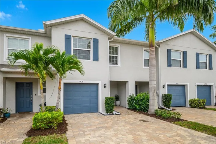 Traditional-style house with stucco siding, decorative driveway, and an attached garage