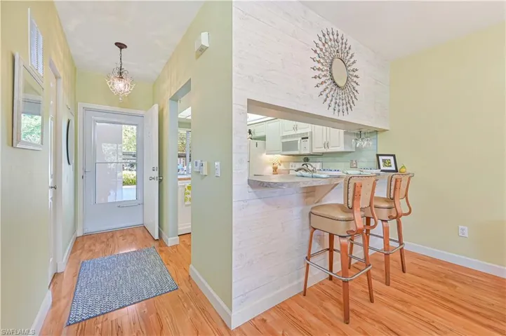 Entryway featuring light wood-style flooring, baseboards, and a chandelier