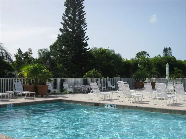 Community pool featuring fence and a patio