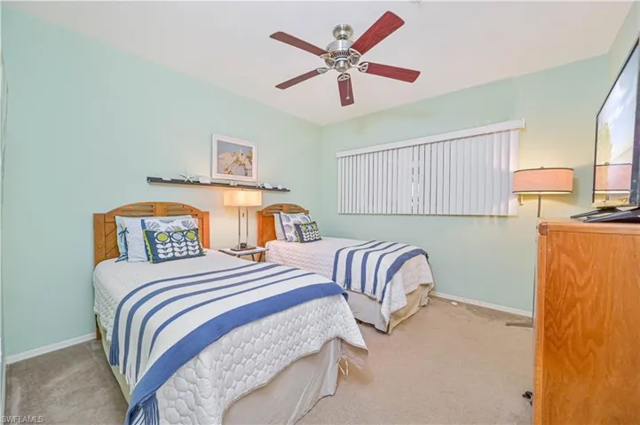 Carpeted bedroom featuring a ceiling fan and baseboards