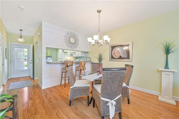 Dining room featuring baseboards, light wood-style flooring, and a notable chandelier