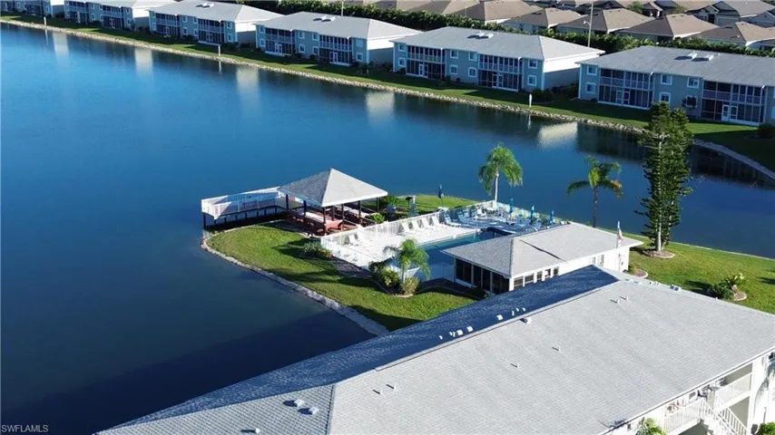 Aerial view of community pool, clubhouse, and pier