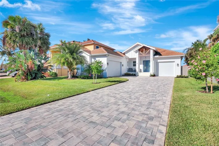 View of front of home featuring a paved driveway.
