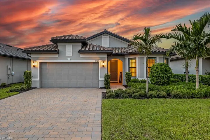 Mediterranean / spanish home with a garage and a lawn