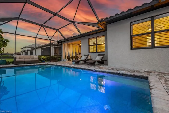 Pool at dusk featuring outdoor lounge area, a patio area, and a lanai