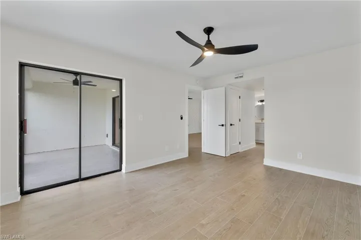 Unfurnished bedroom with a closet, light wood-style flooring, ceiling fan, and connected bathroom