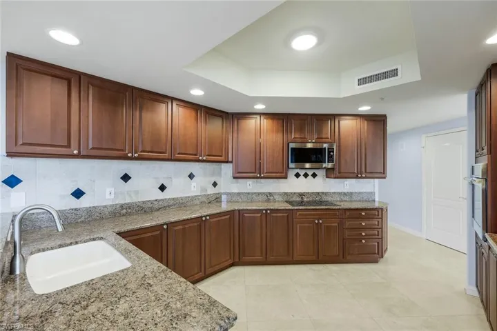Monogram appliances, induction cooktop, and floor to ceiling windows.