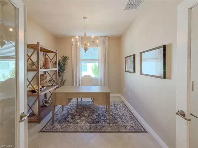 Office with a chandelier and light tile patterned floors