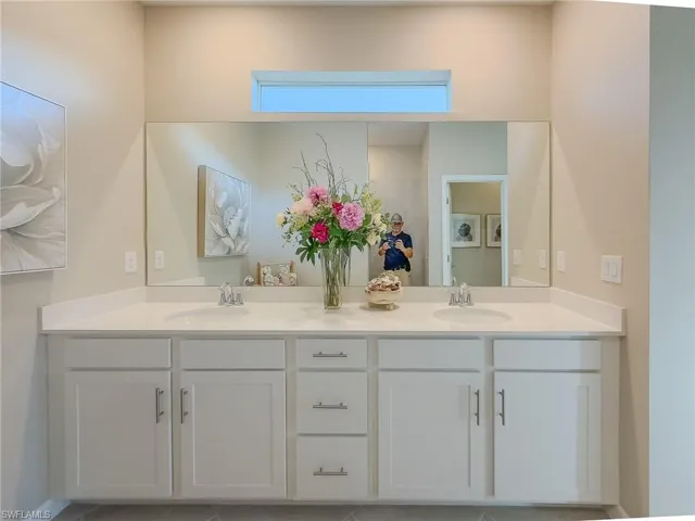 Full bathroom featuring double vanity and light tile patterned flooring