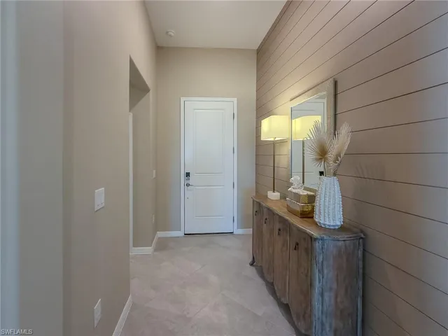 Doorway featuring wood walls and tile patterned floors