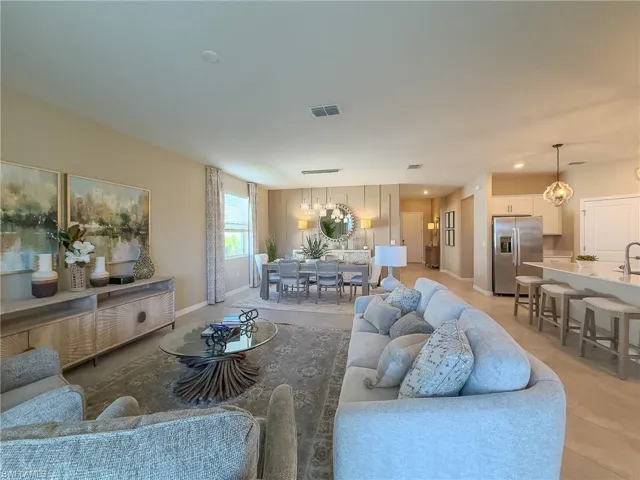 Living room with light tile patterned floors, a chandelier, and recessed lighting