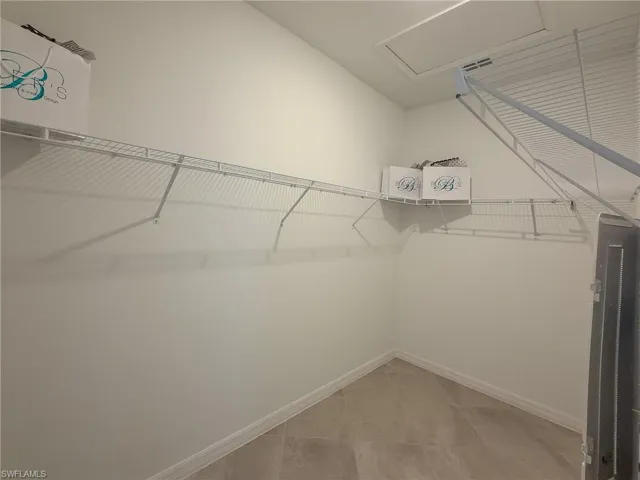 Spacious closet with light tile patterned floors