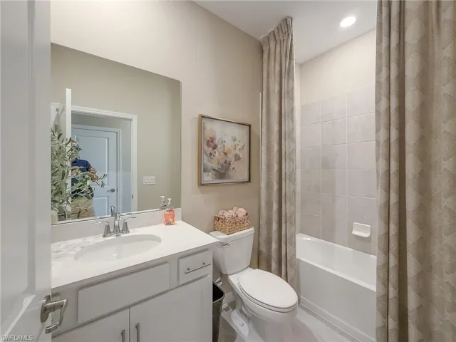 Full bathroom featuring shower / bathtub combination with curtain and vanity