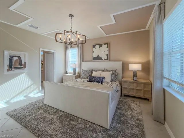 Bedroom with tile patterned floors and a chandelier