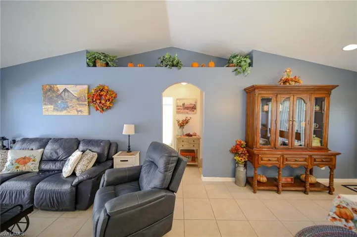 Living room with lofted ceiling and light tile patterned flooring