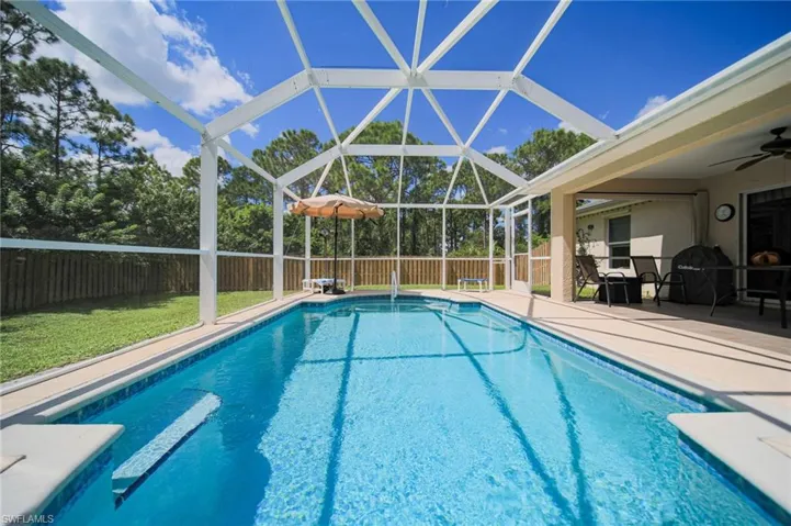 Enjoy this amazing swimming pool featuring a covered and screened lanai, a patio, ceiling fan, and fenced-in back yard.