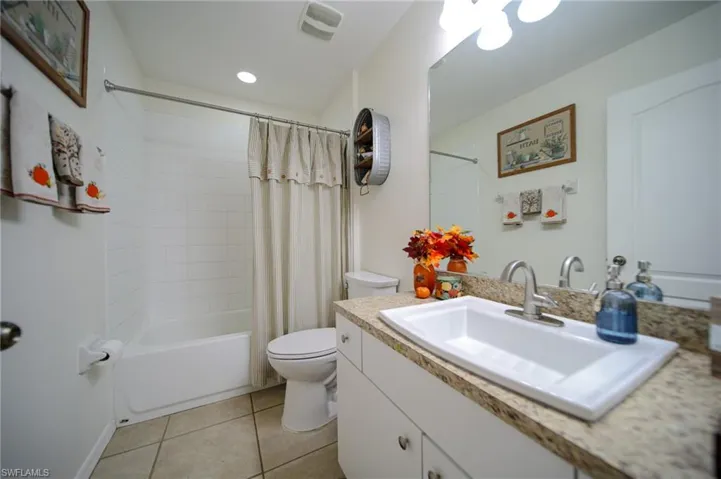 Bathroom #2 comes with a vanity, shower / bath combo with shower curtain, toilet, and tile patterned flooring.