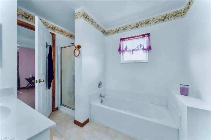 Full bath featuring a bath, vanity, a shower stall, and tile patterned floors