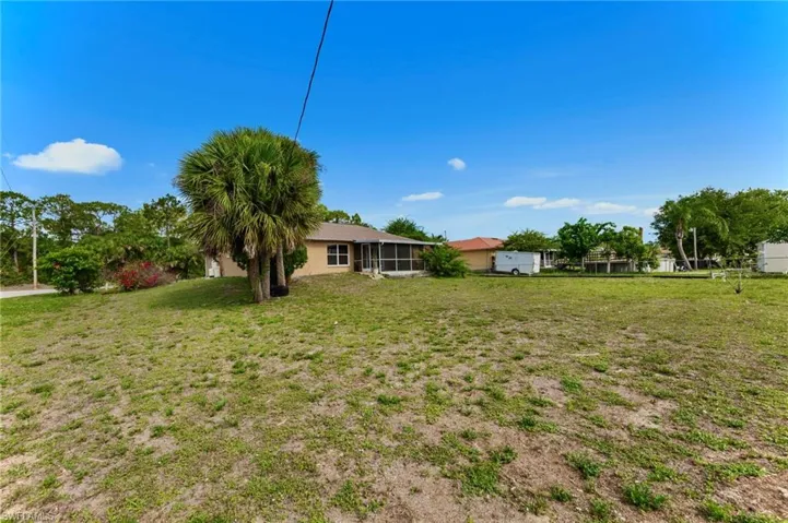View of grassy yard featuring a sunroom