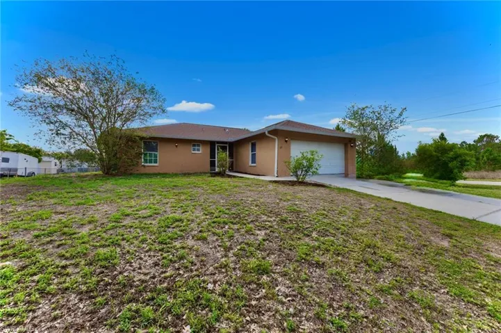 Ranch-style home with a garage, stucco siding, and driveway