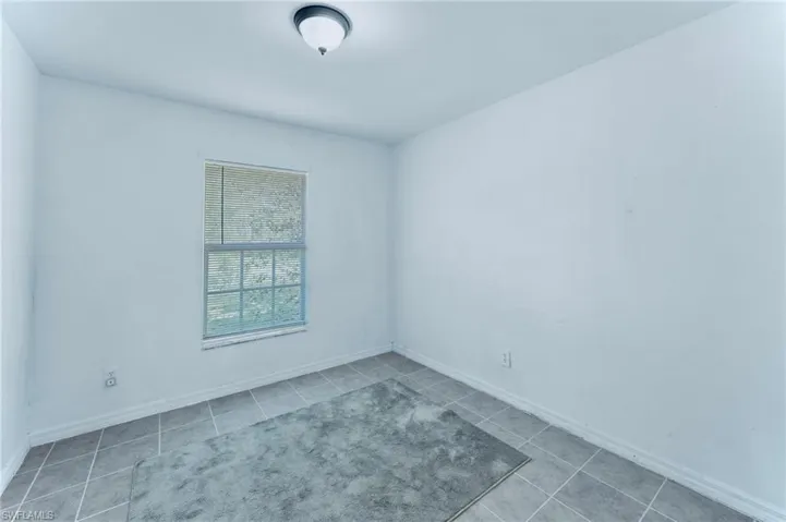 Tiled empty room featuring baseboards