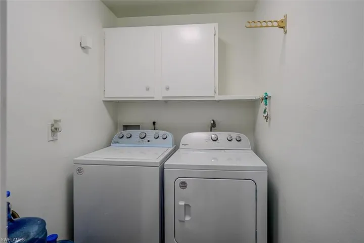 Laundry area with cabinets and washing machine and clothes dryer