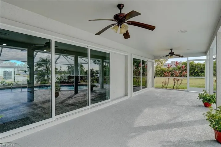 Unfurnished sunroom featuring ceiling fan and a swimming pool