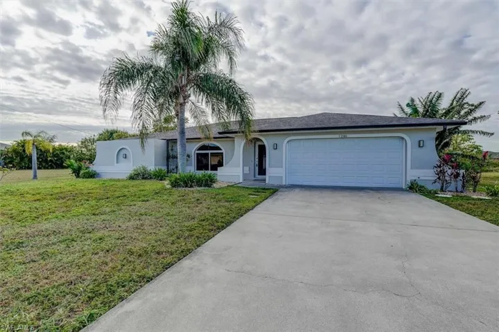 Single story home featuring a front yard and a garage
