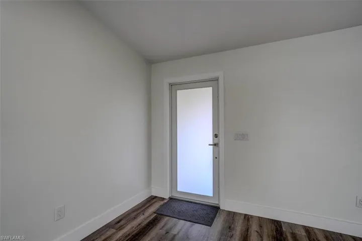 Doorway to outside with dark hardwood / wood-style flooring