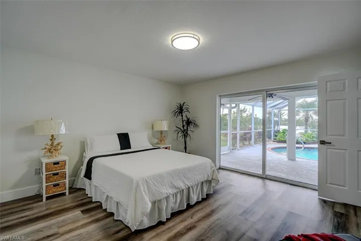 Bedroom featuring access to exterior and dark wood-type flooring