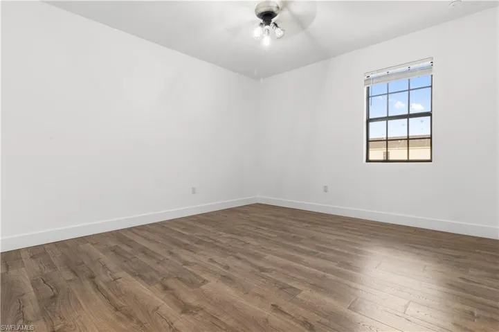 Empty room featuring dark wood-style floors and a ceiling fan