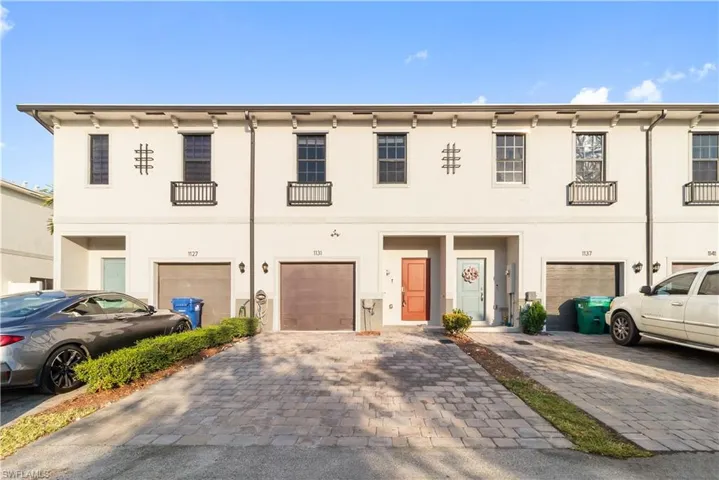 View of front of property with driveway, a garage, and stucco siding