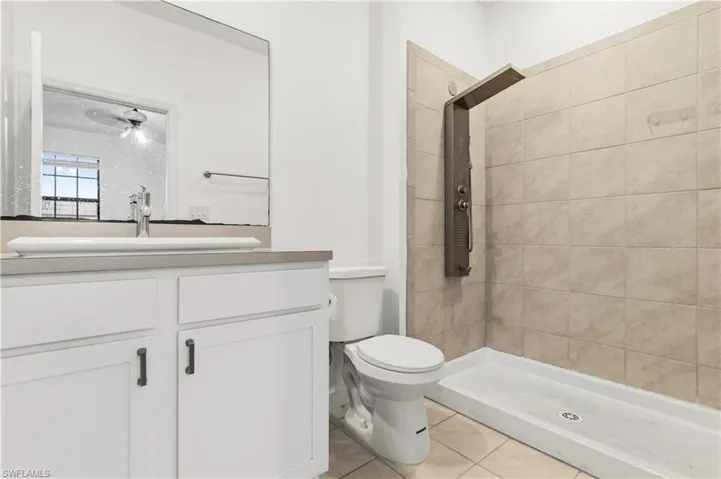 Bathroom with a stall shower, vanity, and light tile patterned floors