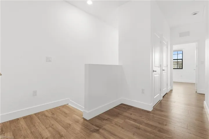 Corridor featuring wood finished floors