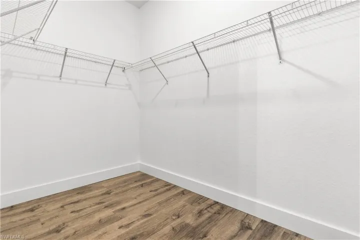 Walk in closet with wood finished floors