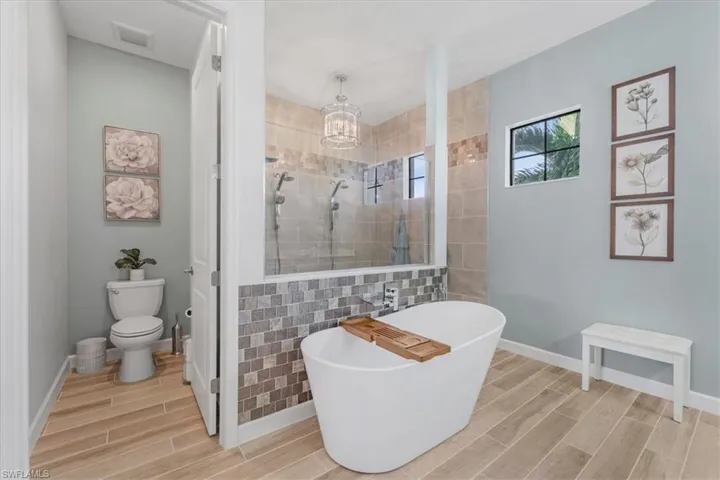 Full bath featuring wood tiled floors, walk in shower, and a freestanding tub