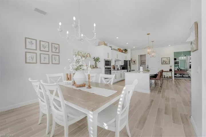 Dining space featuring a chandelier, wood tiled floors, and recessed lighting