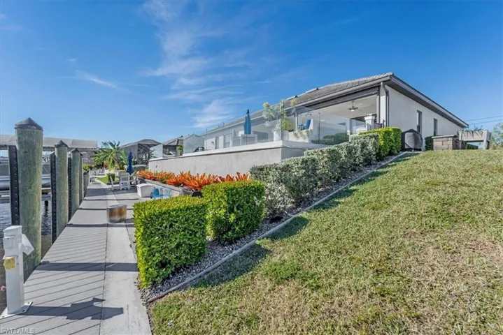 View of property exterior featuring a yard and a dock