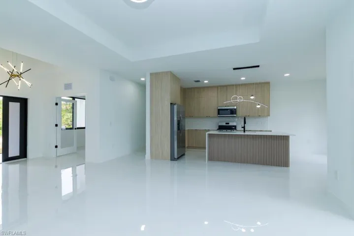 Kitchen with light countertops, visible vents, modern cabinets, appliances with stainless steel finishes, and an inviting chandelier